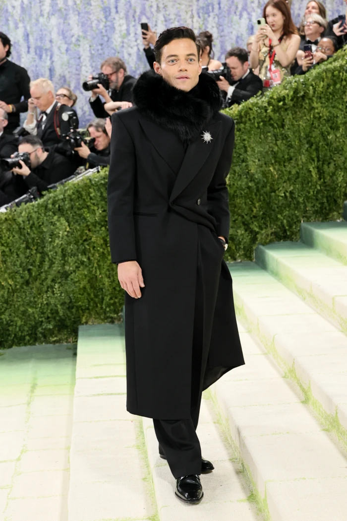 Aktor Rami Malek w płaszczu i futrzanym kołnierzu Saint Laurent